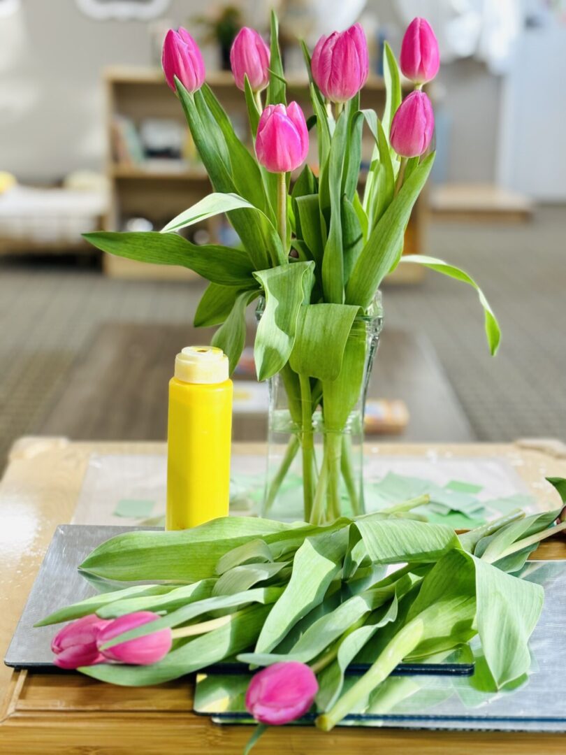 A table with flowers and a yellow bottle